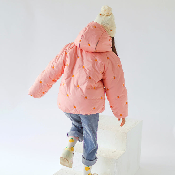 Photo d'un enfant de dos portant la tuque crème en tricot avec broderies fruitées, enfant