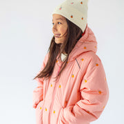 Photo d'un enfant portant la tuque crème en tricot avec broderies fruitées, enfant