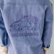 Zoom de l'imprimé au dos d’une voiture et du logo « SRSMN de  la chemise bleu chiné en coton chambray, enfant