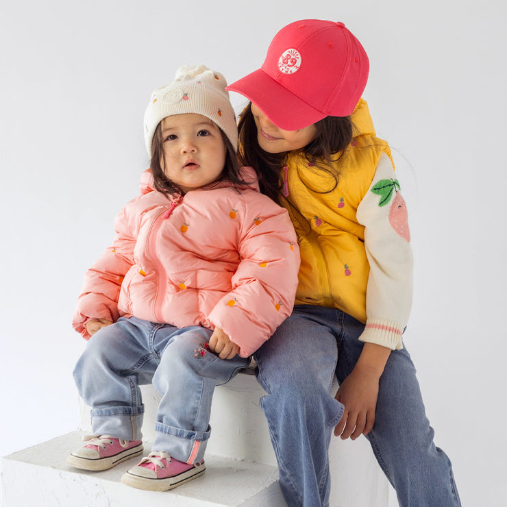 Photo d'un enfant portant la tuque en tricot crème avec broderies fruitées, bébé
