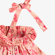 Détail de la robe rose à motif floral, bébé
